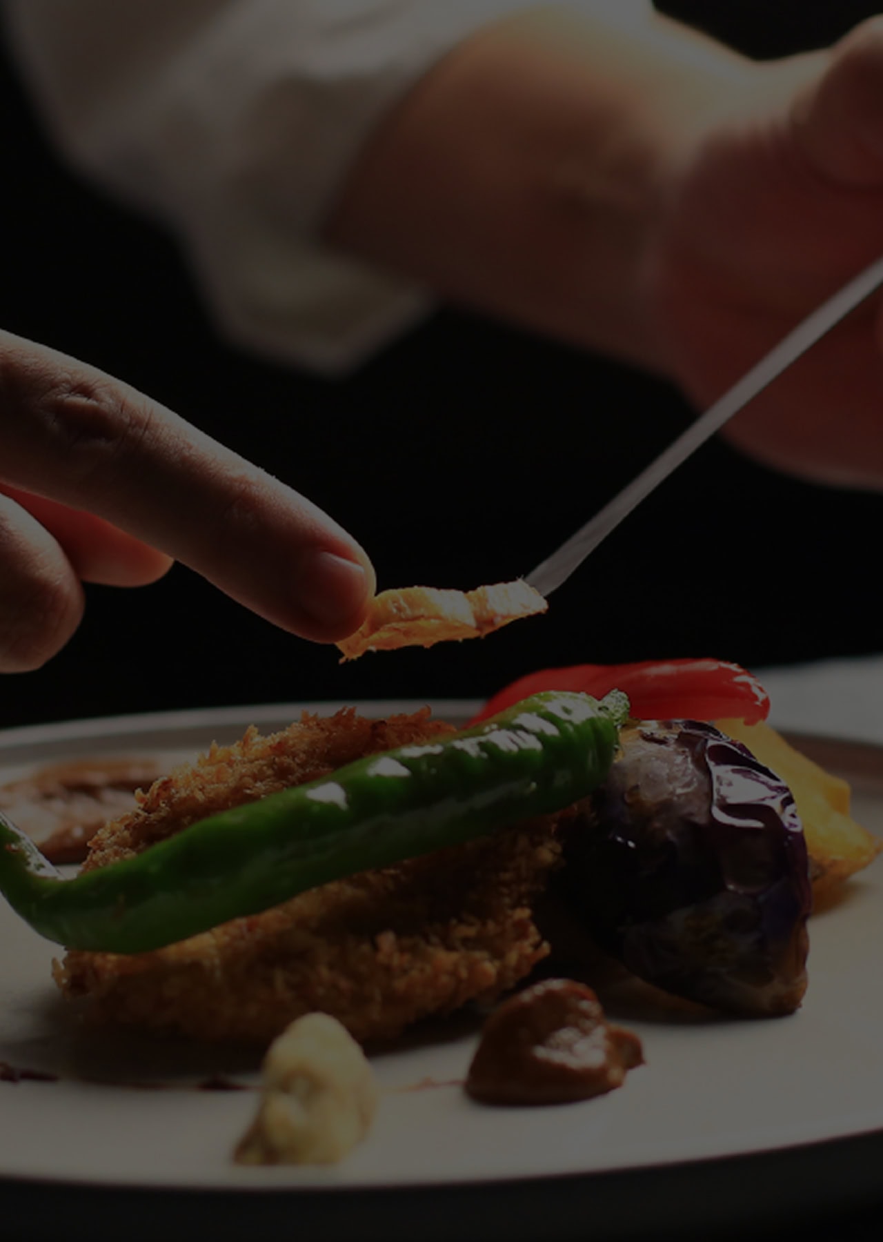 料理を盛り付けるシェフの手元