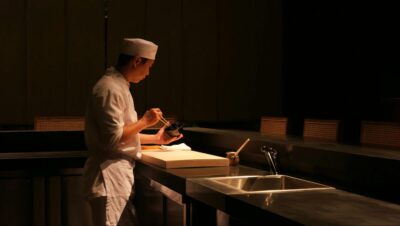 厨房で料理を準備するシェフのシルエットと調理器具.
